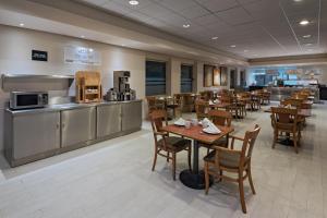 a restaurant with tables and a kitchen and a cafeteria at Four Points by Sheraton Monterrey Linda Vista in Monterrey