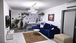 un soggiorno con divano blu e una cucina di Komfortowy dom z jacuzzi blisko Trójmiasta a Banino