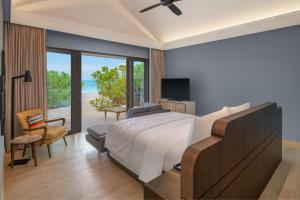 Le Méridien Maldives Resort & Spa في لْهلفياني أتول: غرفة نوم مع سرير وإطلالة على المحيط