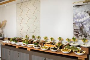 una línea de buffet con tazones de plantas. en Elan Hotel Istanbul Pera, en Estambul