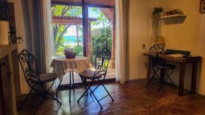 坎布塔爾的住宿－Charming Cabaña on the beach，一间带桌椅和窗户的用餐室
