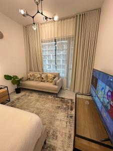 a bedroom with a couch and a tv in a room at Modern Home in Al Qurayyah