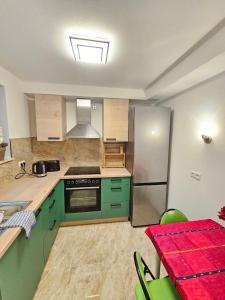 - une cuisine avec des placards verts et une cuisinière dans l'établissement schöne Wohnung am Georgenberg, à Reutlingen