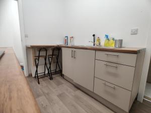 a kitchen with a counter and a sink with stools at Adorable 2BR Apartment in The Rock Bury in Bury