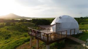 una casa iglú con terraza y balcón en Domescape Glamping, en El Cedro