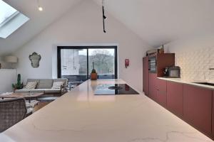eine Küche mit einer Arbeitsplatte und ein Wohnzimmer in der Unterkunft Appartement (8 pers.) design. in Profondeville