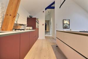 cocina con armarios marrones y suelo de madera en Appartement (8 pers.) design. en Profondeville