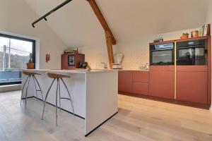 uma cozinha com um balcão branco e armários vermelhos em Appartement (8 pers.) design. em Profondeville