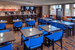 a restaurant with blue tables and blue chairs at Courtyard Texarkana in Texarkana - Texas