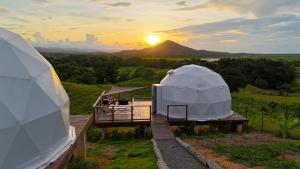 una vista su una yurta con il tramonto sullo sfondo di Domescape Glamping a El Cedro