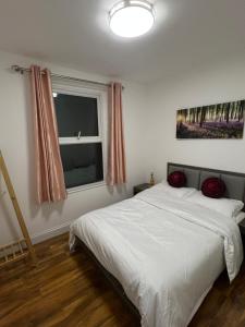 a bedroom with a white bed and a window at Cromer House in Horsham Saint Faith