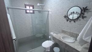 a white bathroom with a sink and a mirror at Pousada Estrelar in Lençóis