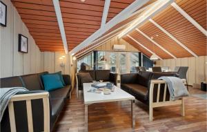 een woonkamer met banken en een tafel bij Lovely Home In Aakirkeby With Kitchen in Vester Sømarken