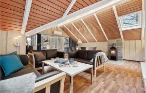 uma sala de estar com uma mesa e uma lareira em Lovely Home In Aakirkeby With Kitchen em Vester Sømarken