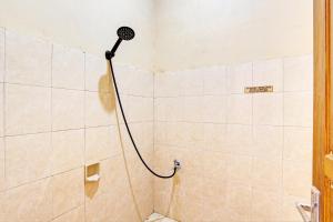 a shower with a shower head in a bathroom at OYO 93208 Guest House Cemara 2 in Brebes