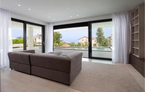 a living room with a couch and large windows at Beautiful Apartment In Malinska in Malinska
