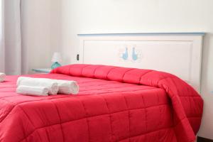 a red bed with two towels on top of it at B&B Bellavista Posada in Posada