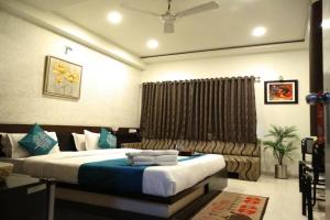 ein Schlafzimmer mit einem großen Bett mit blauen Kissen in der Unterkunft Hotel Crown in Rajkot