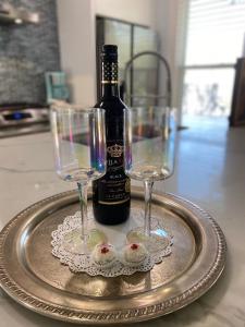 a bottle of wine and two glasses on a tray at Luxury Designer Villa by the Beach Bright Beautiful Brand New in Galveston
