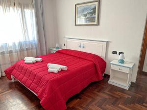 a bedroom with a red bed with towels on it at B&B Bellavista Posada in Posada