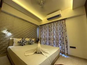 een slaapkamer met een groot bed en een raam bij 1.5BR Service apartment in BKC by Florastays in Mumbai
