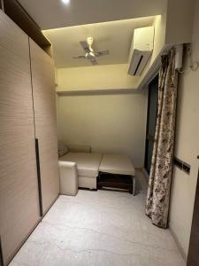 een kamer met een bed en een plafondventilator bij 1.5BR Service apartment in BKC by Florastays in Mumbai