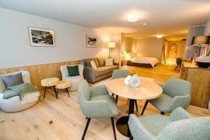 een woonkamer met een bank en een tafel en stoelen bij Seven Alpina Boutique Hotel in Klosters Serneus