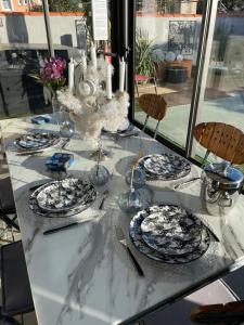 una mesa con platos azules y blancos. en Relaxation AquatiqueGarantie100% en Saint-Estève