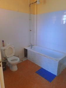 a bathroom with a toilet and a bath tub at Elite homes in Kisumu