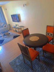 a room with a table and chairs and a living room at Elite homes in Kisumu