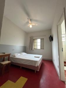 - une chambre avec un lit et un ventilateur de plafond dans l'établissement Hotel Uirapuru, à Araraquara