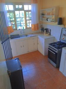 een keuken met witte kasten en een fornuis met oven bij Elite homes in Kisumu
