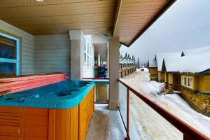 een hot tub op het balkon van een huis in de sneeuw bij Tree Tops 10 in Big White