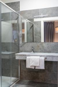 a bathroom with a sink and a glass shower at Flom Boutique Hotel in Florence