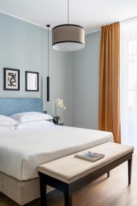 Un dormitorio con una gran cama blanca y una mesa en Flom Boutique Hotel en Florence