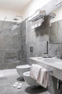 a bathroom with a sink and a toilet and a shower at Flom Boutique Hotel in Florence