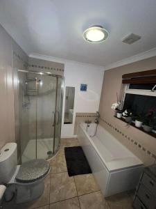 a bathroom with a shower and a tub and a toilet at House in Lisburn road in Belfast