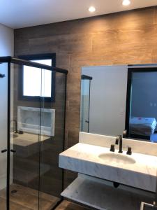 a bathroom with a sink and a glass shower at Casa X in Campos do Jordão