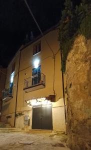 a building with a door and a balcony at night at B & B Domus San PietRo in Rossano