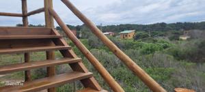 a wooden ladder looking out over a field with a house at Shiatsu Rocha in Montevideo