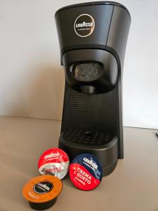 a black coffee maker with four stickers on it at Appartamento Levico in Levico Terme