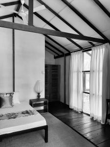 a bedroom with a bed and a large window at Elephant Lodge in Udawalawe