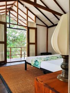 ein Schlafzimmer mit einem Bett und einem großen Fenster in der Unterkunft Elephant Lodge in Udawalawe