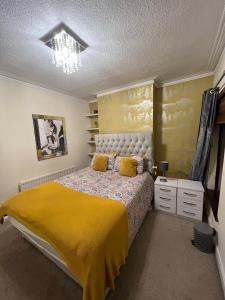 a bedroom with a large bed with a yellow blanket at House in Lisburn road in Belfast