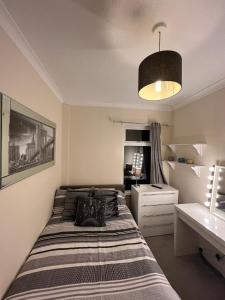 a bedroom with a bed and a desk and a lamp at House in Lisburn road in Belfast