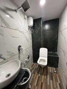 a bathroom with a sink and a toilet at HOTEL GOLDEN VIEW in Vadodara