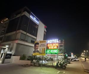 un hotel con señales frente a un edificio en HOTEL GOLDEN VIEW, en Vadodara