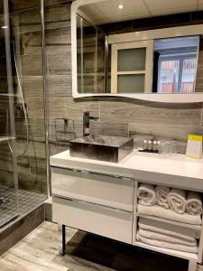 a bathroom with a sink and a shower at Hôtel La Réserve in Gérardmer