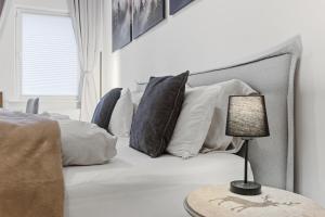 a bedroom with a bed with pillows and a table with a lamp at Stilvolles City-Apartment - Pfalzliebe Suites in Landau in der Pfalz