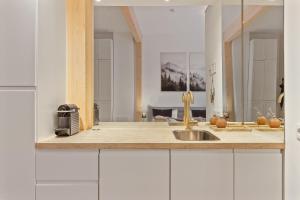 a kitchen with white cabinets and a sink at Stilvolles City-Apartment - Pfalzliebe Suites in Landau in der Pfalz